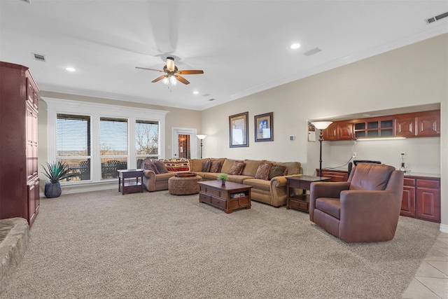 living room featuring light tile patterned floors, ornamental molding, and ceiling fan