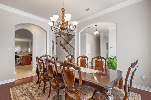 dining room featuring an inviting chandelier, hardwood / wood-style floors, and crown molding