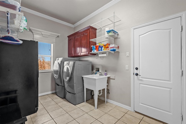 laundry area featuring light tile patterned floors, crown molding, cabinets, and washing machine and clothes dryer