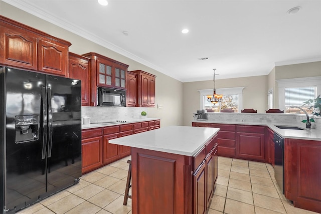 kitchen with sink, a center island, hanging light fixtures, decorative backsplash, and black appliances