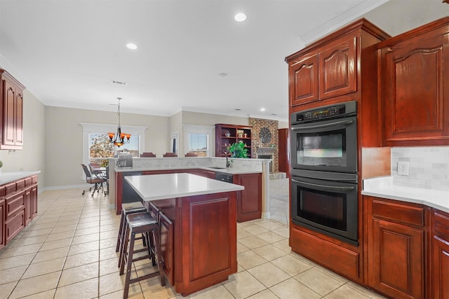 kitchen featuring sink, double oven, a center island, decorative backsplash, and decorative light fixtures