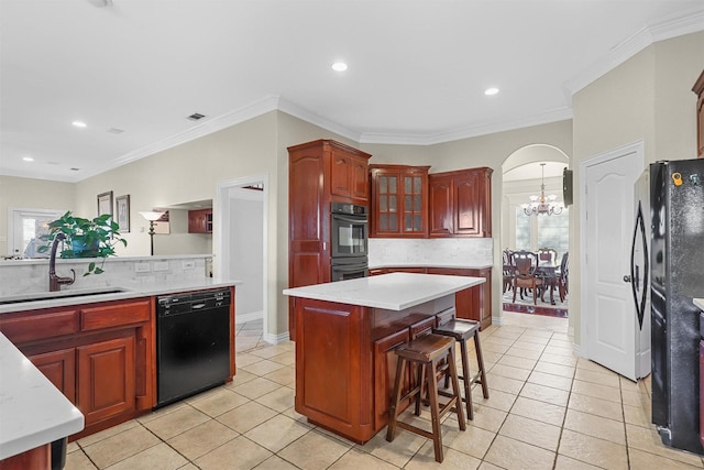 kitchen featuring sink, black appliances, a center island, and light tile patterned flooring