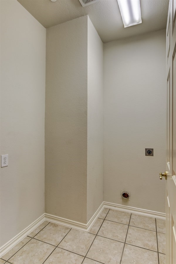 washroom with light tile patterned flooring and hookup for an electric dryer