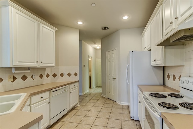 kitchen featuring sink, white cabinets, decorative backsplash, light tile patterned floors, and white appliances