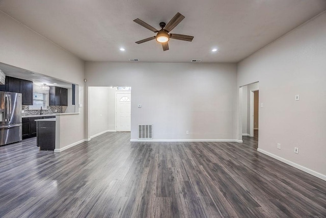 unfurnished living room with ceiling fan, sink, and dark hardwood / wood-style flooring