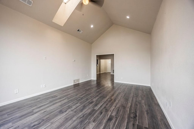 unfurnished room featuring ceiling fan, dark hardwood / wood-style floors, a skylight, and high vaulted ceiling