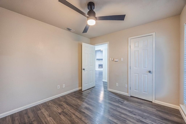 unfurnished bedroom with ceiling fan and dark hardwood / wood-style flooring