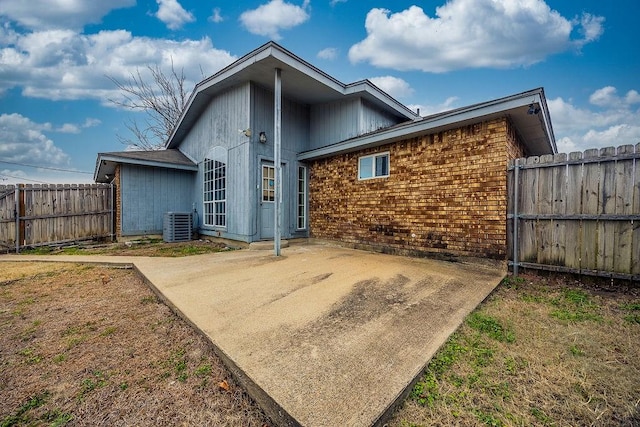 rear view of property featuring central AC unit and a patio area