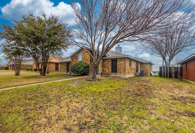 single story home with central AC unit and a front lawn