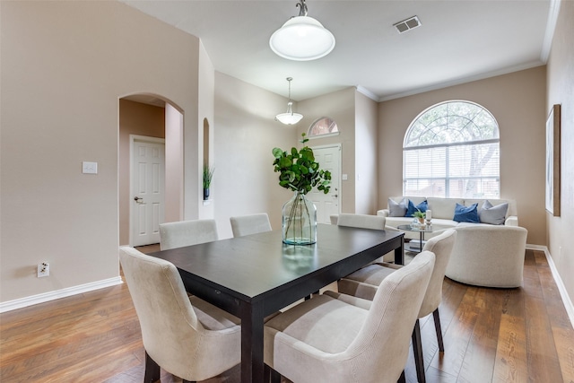 dining area featuring crown molding and wood-type flooring