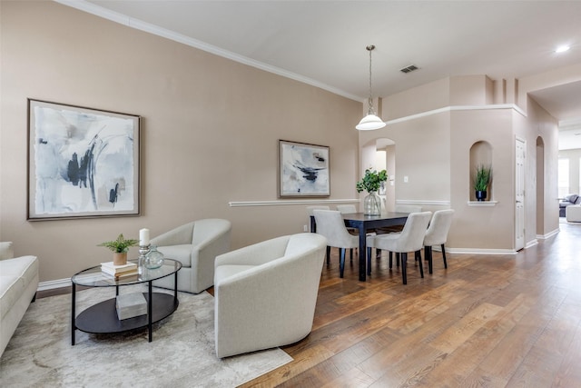 dining room with hardwood / wood-style floors and ornamental molding