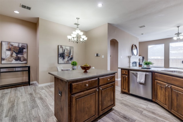 kitchen featuring pendant lighting, sink, a center island, stainless steel dishwasher, and light hardwood / wood-style floors