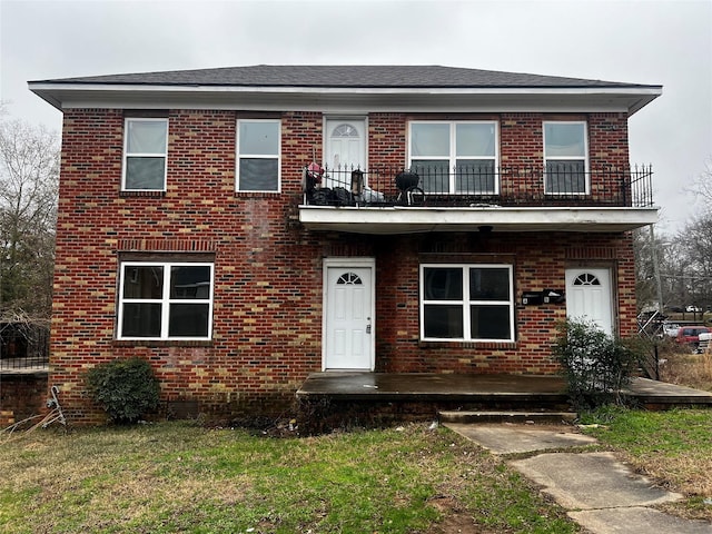 view of front of home with a front lawn and a balcony