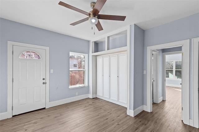 foyer featuring light hardwood / wood-style flooring, ceiling fan, and plenty of natural light