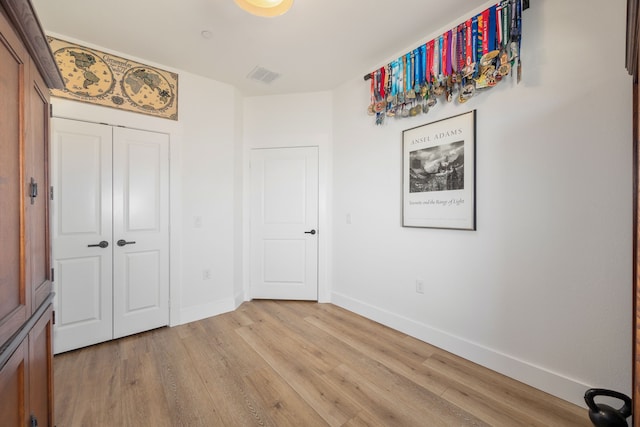 unfurnished bedroom featuring light hardwood / wood-style flooring and a closet