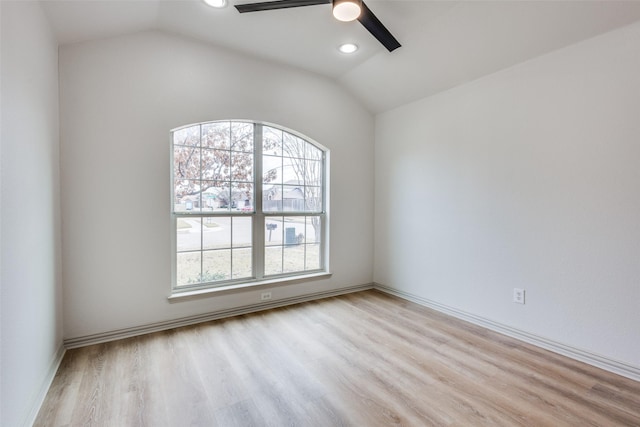 spare room featuring lofted ceiling, ceiling fan, and light wood-type flooring