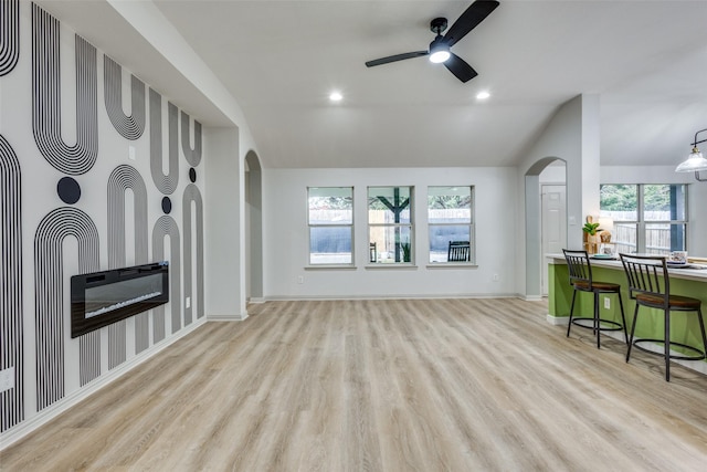 living room with vaulted ceiling, ceiling fan, and light hardwood / wood-style flooring