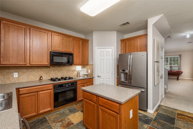 kitchen with tasteful backsplash, sink, a kitchen island, and black appliances