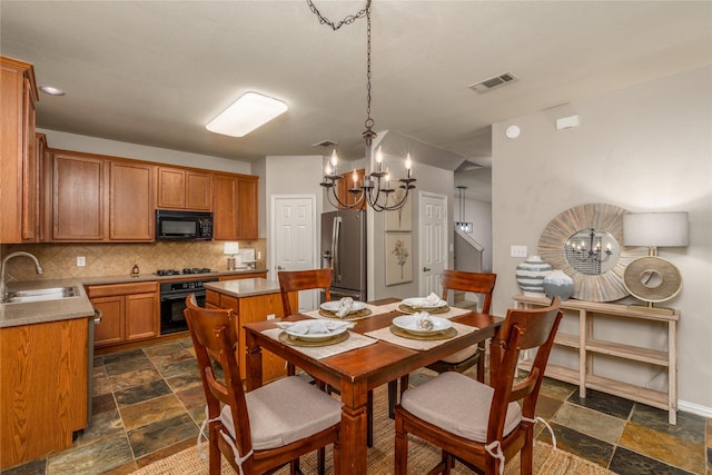 dining room featuring sink and a notable chandelier