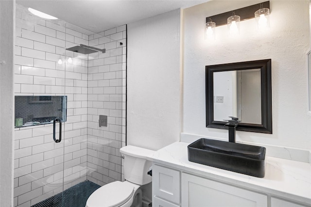 bathroom featuring vanity, a shower with shower door, and toilet