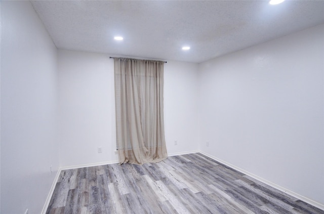 empty room featuring light hardwood / wood-style flooring and a textured ceiling