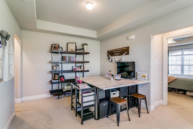 office area with light colored carpet and a tray ceiling