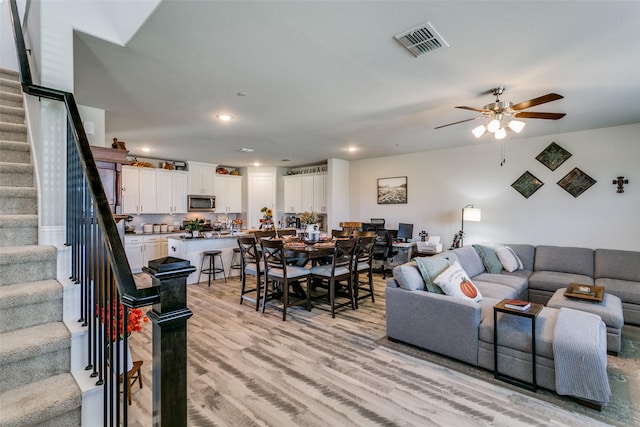 living room featuring ceiling fan and light wood-type flooring