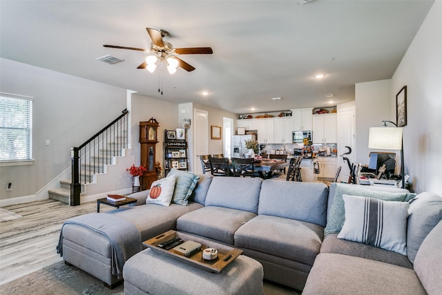 living room with ceiling fan and light wood-type flooring