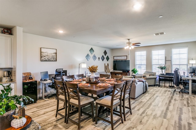 dining space with ceiling fan and light wood-type flooring