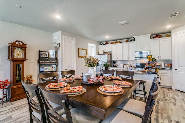 dining space featuring sink and light hardwood / wood-style floors