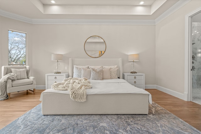 bedroom featuring ornamental molding, a tray ceiling, and hardwood / wood-style floors