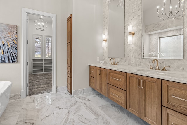 bathroom featuring vanity, a notable chandelier, and a washtub