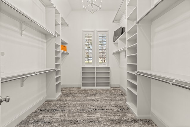 spacious closet featuring wood-type flooring and an inviting chandelier