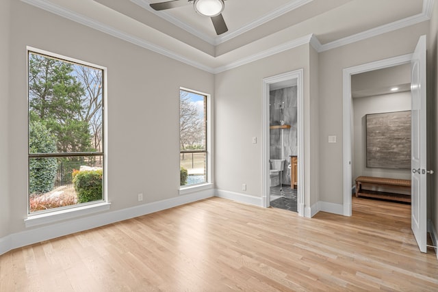 interior space featuring ornamental molding, a tray ceiling, ceiling fan, and light hardwood / wood-style flooring