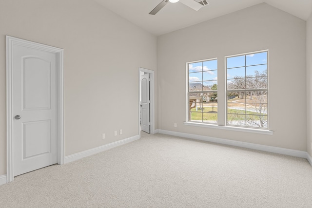 spare room with ceiling fan, light colored carpet, and vaulted ceiling