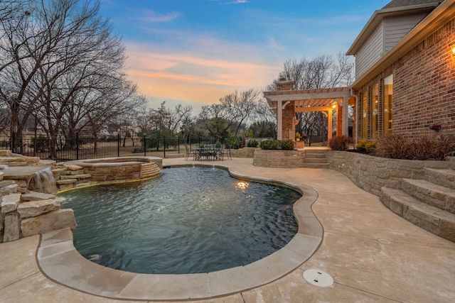 pool at dusk with an in ground hot tub, pool water feature, and a patio area