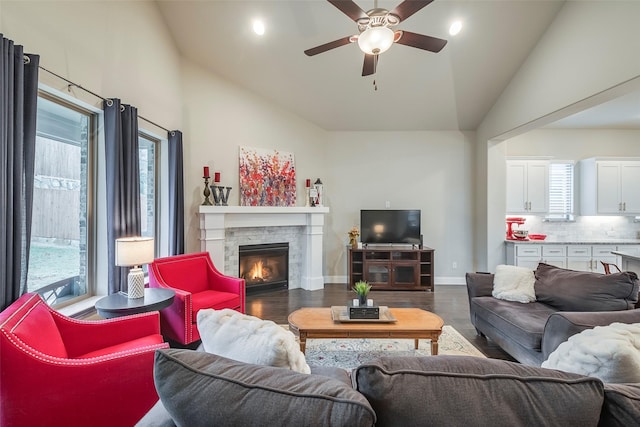 living room with ceiling fan, a fireplace, dark hardwood / wood-style flooring, and high vaulted ceiling