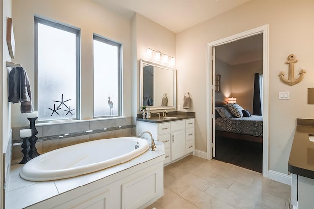 bathroom with tile patterned floors, vanity, and a tub