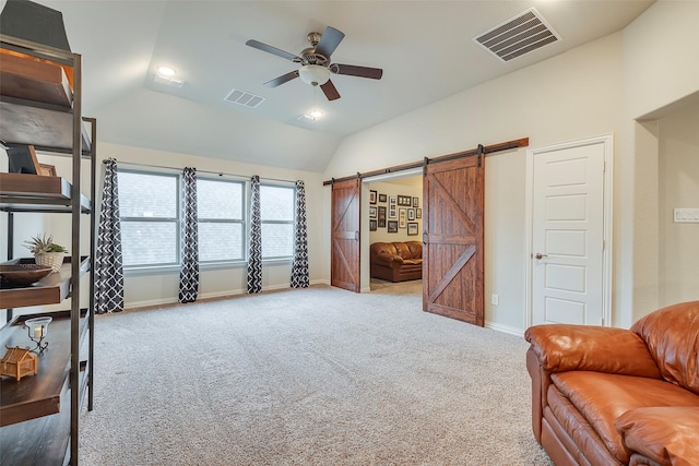 interior space with vaulted ceiling, a barn door, light colored carpet, and ceiling fan