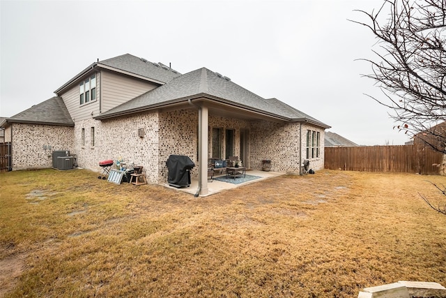 rear view of house featuring a yard, central AC, and a patio area