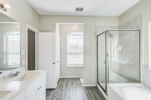 bathroom featuring vanity, independent shower and bath, and hardwood / wood-style floors