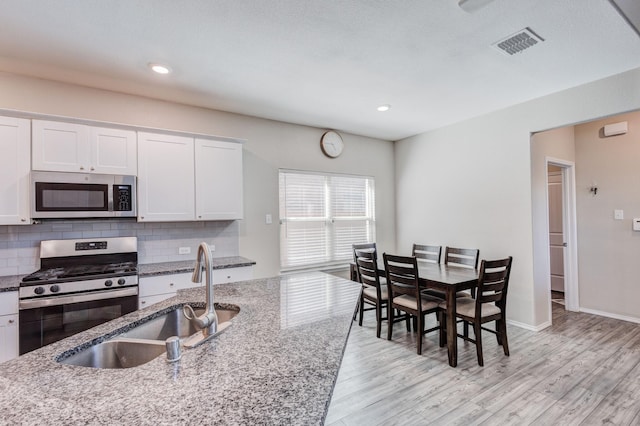 kitchen with white cabinetry, appliances with stainless steel finishes, sink, and tasteful backsplash