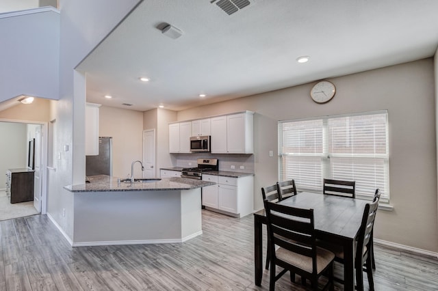 kitchen featuring light stone counters, sink, white cabinets, and appliances with stainless steel finishes