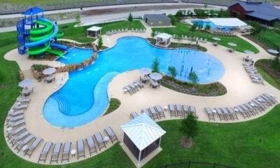 view of pool featuring a lawn, a playground, and a water slide