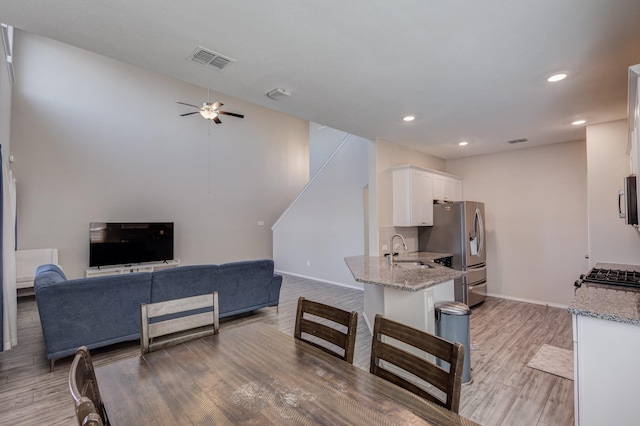 dining room with sink, light hardwood / wood-style floors, and ceiling fan