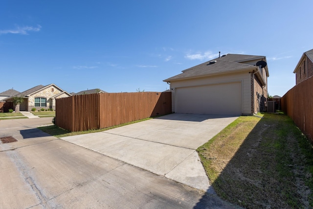 view of side of property with a garage and central air condition unit