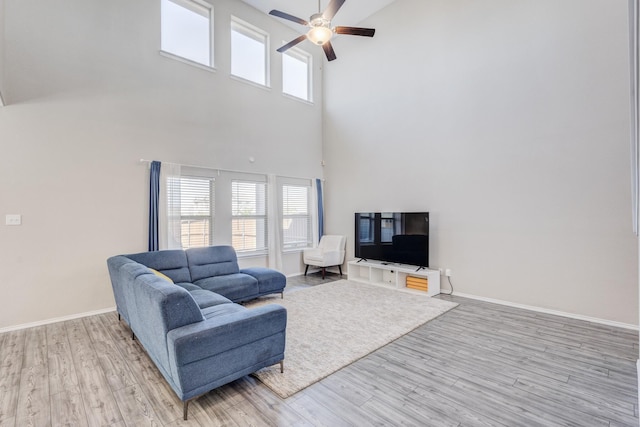 living room with ceiling fan and light wood-type flooring