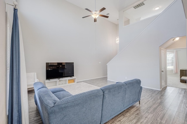 living room featuring hardwood / wood-style floors, high vaulted ceiling, and ceiling fan