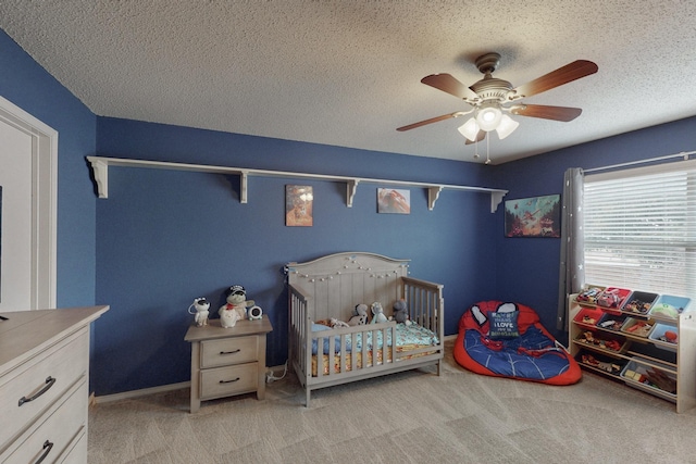 bedroom featuring ceiling fan, light carpet, and a textured ceiling