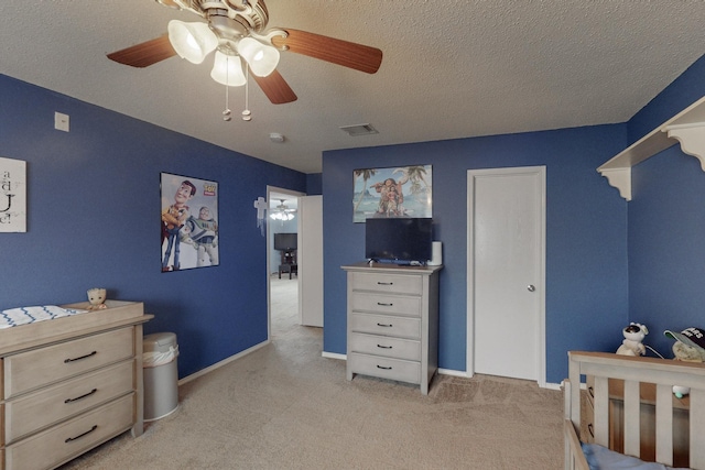 carpeted bedroom with ceiling fan and a textured ceiling